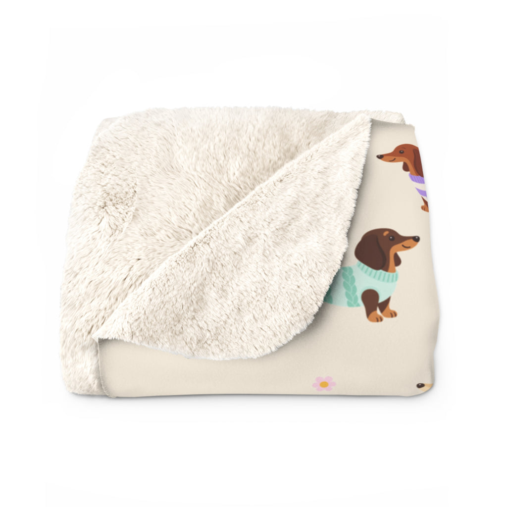 Fluffy sherpa back at a folded corner of the Cream sherpa fleece blanket, beside its printed dachshund front.