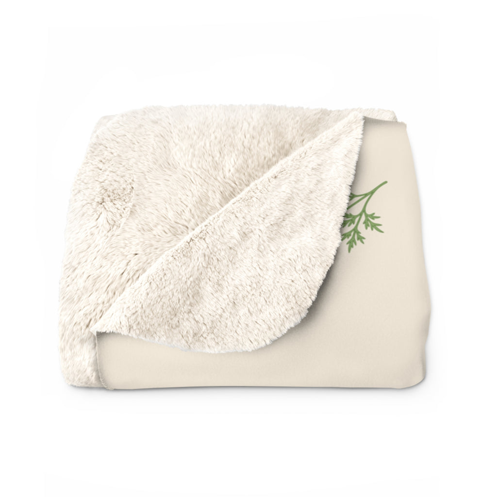 A folded Cream sherpa fleece blanket for Mom shows the fluffy cream back beside a green leafy sprig on the printed front.