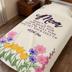 Cream velveteen plush blanket covers a single dark wooden bed, with deep plum words and a wildflower meadow in full color at the foot.
