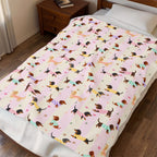 Wiener dog blanket in velveteen plush, Pink stripes color, on a bed with knit-sweater dogs.