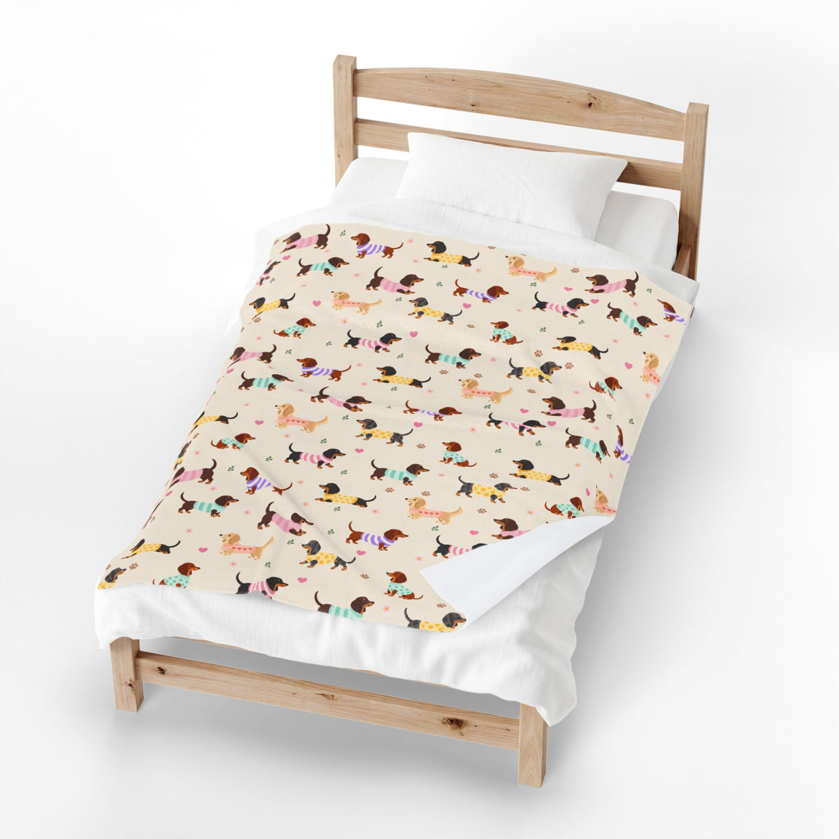 Folded corner of a Cream velveteen plush blanket shows the white back beside the printed sweater-dog front.