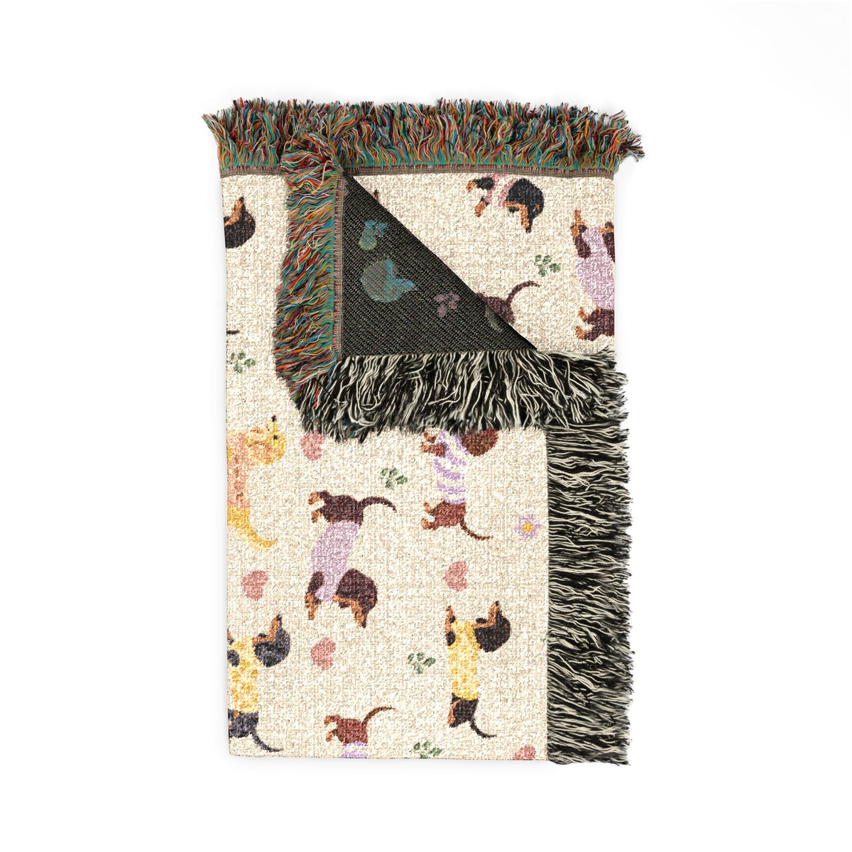 Folded Cream wiener dog throw blanket in woven cotton with dachshunds, a reversed-color back, and fringe.