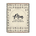 A tall Cream wildflower throw in woven cotton, 60 x 80 inches, lies on white with "Mom" inside a dark arch, even flower rows and fringe.