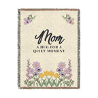 The 60 x 80 inch Cream woven cotton blanket is shown tall on white, with dark words, soft lilac wildflowers and fringe on all four edges.
