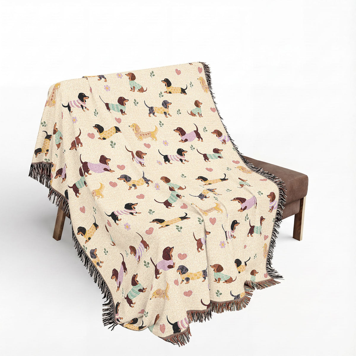 Chair draped with the 60x80 in Cream woven cotton blanket, showing the dachshund design and colorful fringe edges.