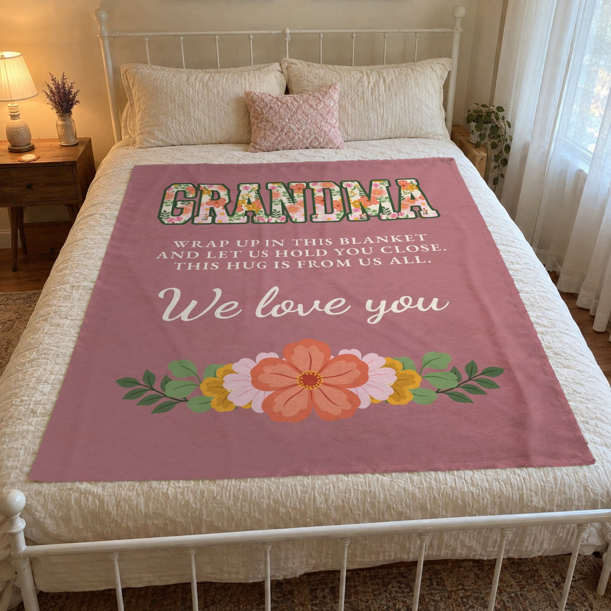 A 50 x 60 inch Dusty rose grandma blanket in velveteen plush lies on a white iron queen bed with cream bedding in a guest room.
