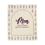 A Cream hug blanket in velveteen plush lies flat on white, showing "Mom" and "A hug for a quiet moment" inside a deep plum arch with flower rows.