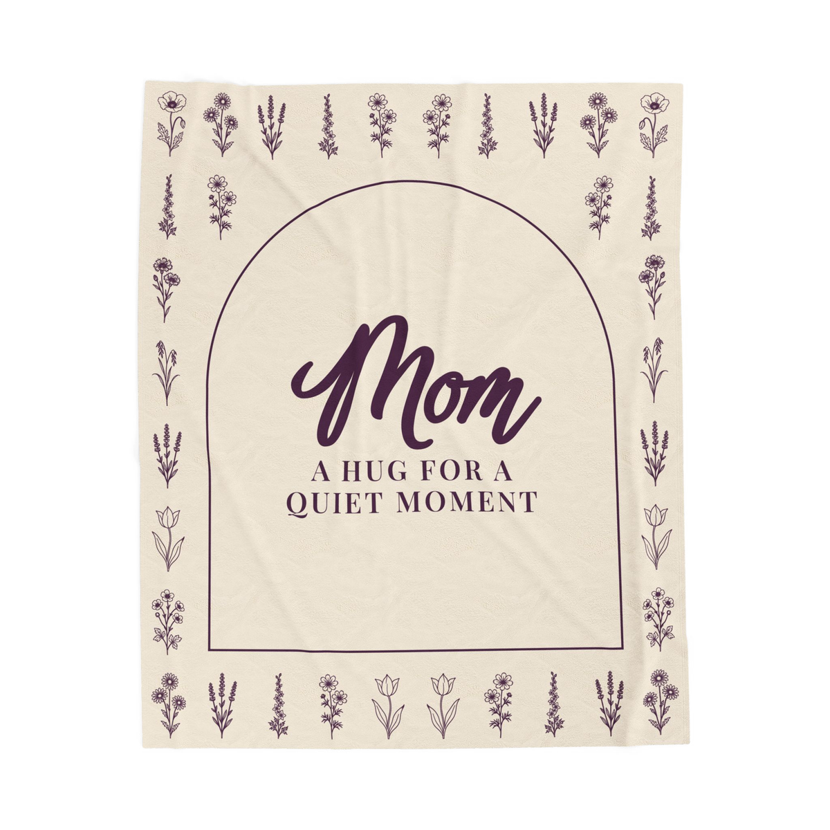 A Cream hug blanket in velveteen plush lies flat on white, showing "Mom" and "A hug for a quiet moment" inside a deep plum arch with flower rows.