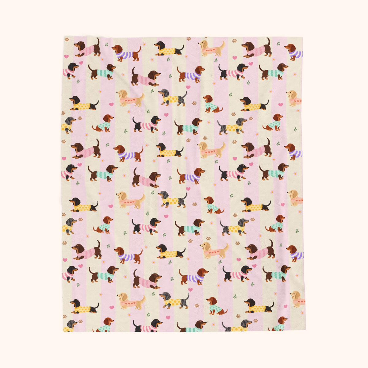 Wide soft cream and blush bands on the Pink stripes velveteen plush blanket, with sweater dogs, laid flat on cream.