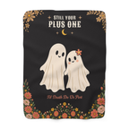 The Black spooky blanket in sherpa fleece lies flat on white, showing two smiling cream ghosts, one with a flower on her head.