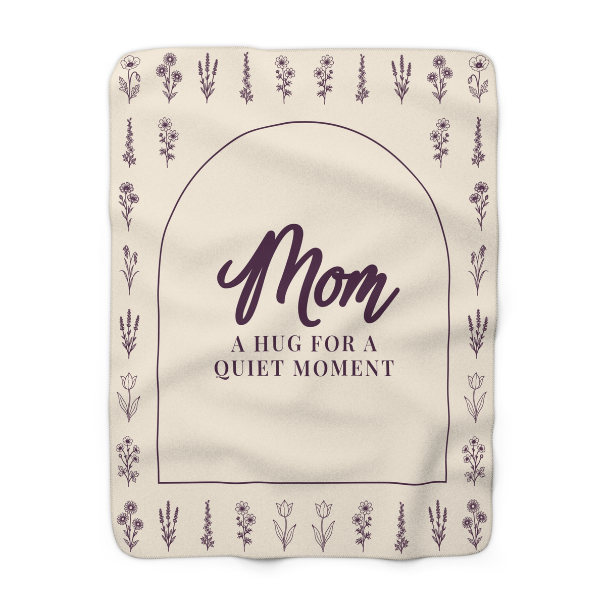 Cream wildflower blanket in sherpa fleece laid flat on white, with "Mom" and "A hug for a quiet moment" inside a deep plum arch.