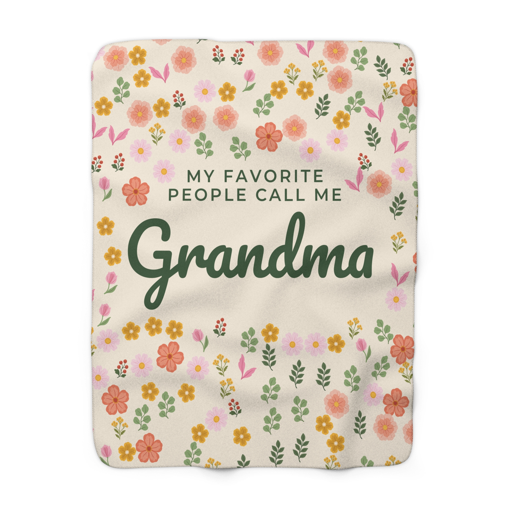 Cream floral blanket in sherpa fleece lies flat on white, with little flowers around "MY FAVORITE PEOPLE CALL ME Grandma" in forest green.