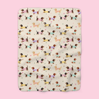 Sweater-wearing dachshunds cover a Cream sherpa fleece blanket laid flat on a soft blush backdrop.