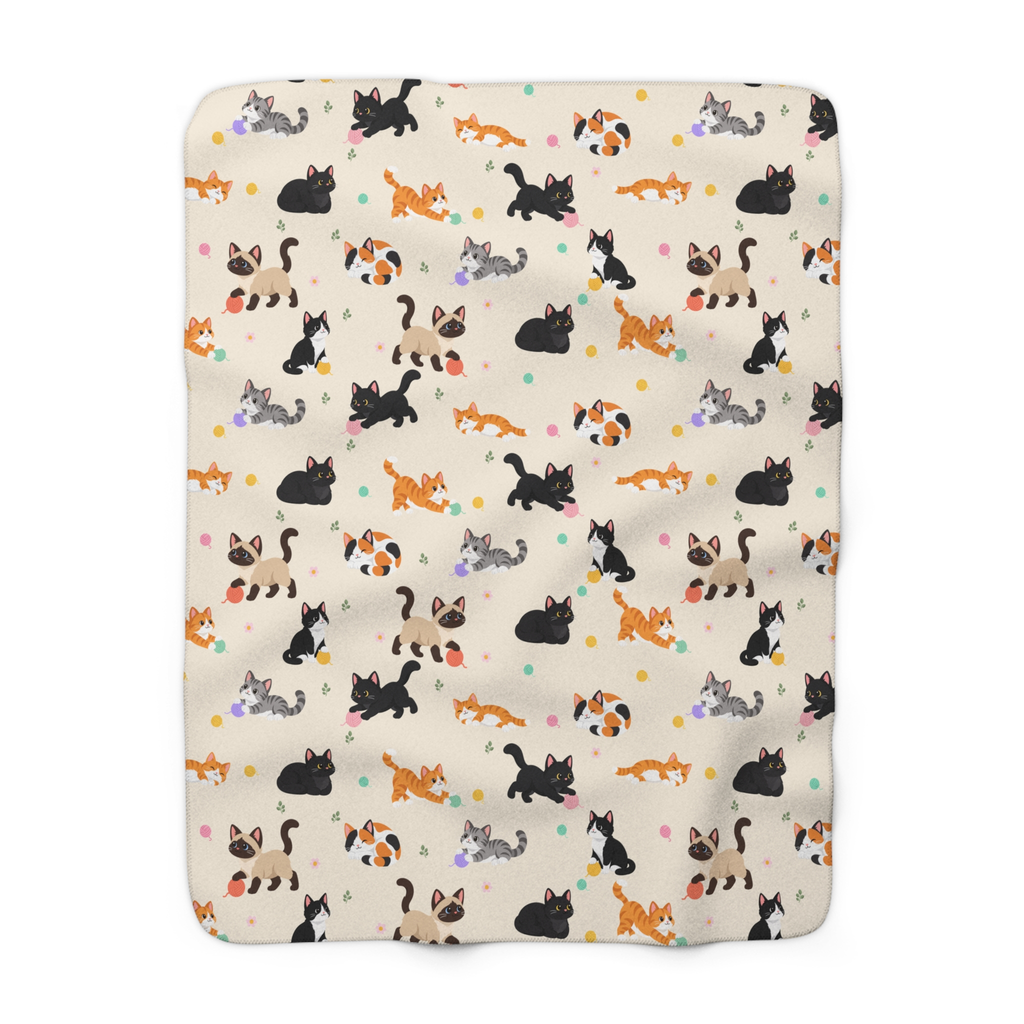Cream cat sherpa blanket laid flat on white, showing cartoon cats, pastel yarn balls and daisies on the printed fleece front.