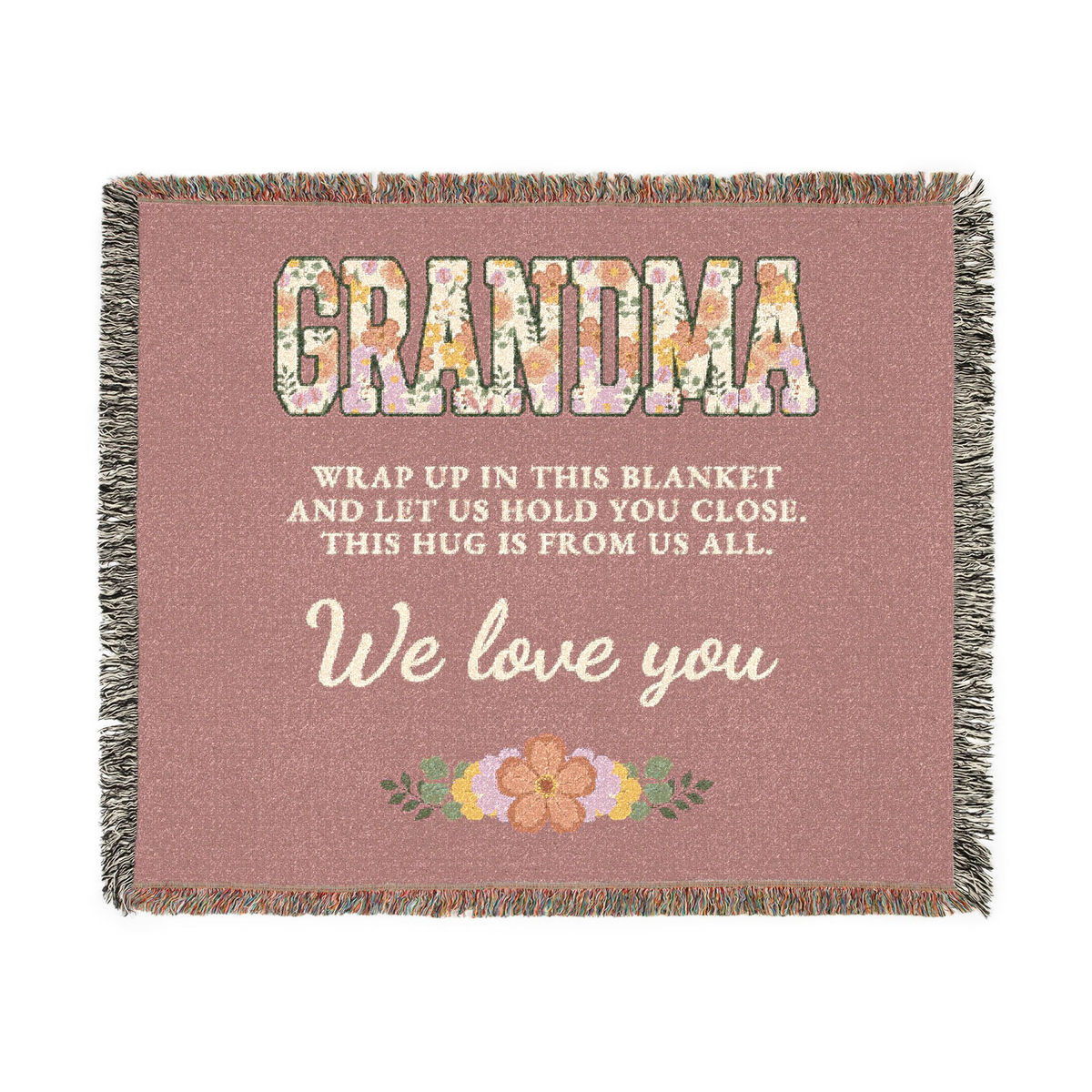Laid flat on white, a Dusty rose grandma throw blanket in woven cotton shows floral "GRANDMA", cream script and fringe on all four sides.