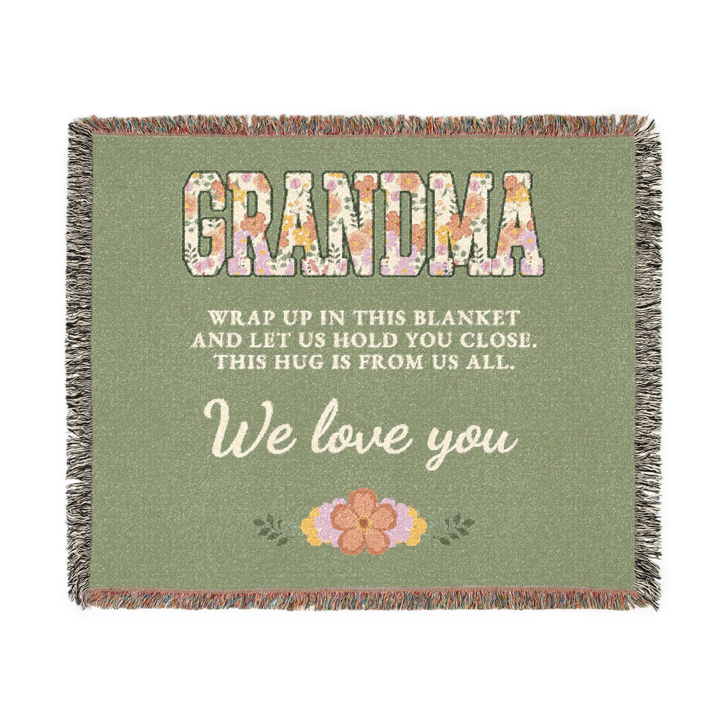 Sage grandma throw blanket in woven cotton lies flat on white, with floral "GRANDMA" capitals, cream words and fringe on all four sides.