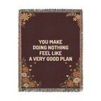 Laid flat on white, a fringed Wine woven cotton blanket reads "You make doing nothing feel like a very good plan" with wildflowers and small hearts.