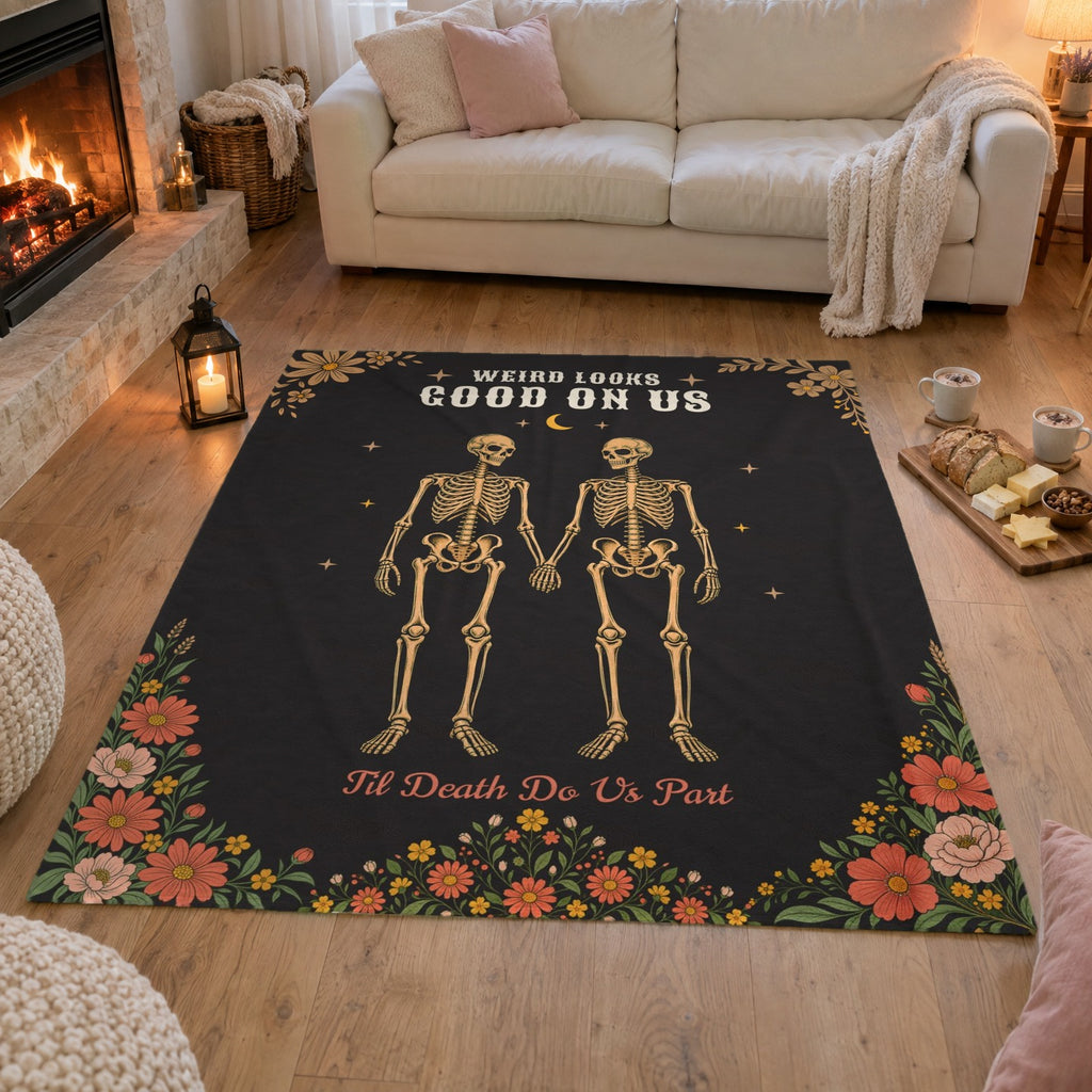 On an oak living room floor, a 50 x 60 inch Black velveteen plush skeleton couple blanket lies beside bread, cheese and cocoa.