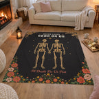 On an oak living room floor, a 50 x 60 inch Black velveteen plush skeleton couple blanket lies beside bread, cheese and cocoa.